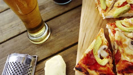 rebanadas de pizza con vasos de cerveza y refrescos