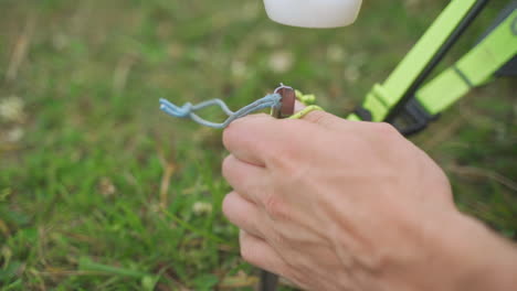 vista estática en cámara lenta de un joven que usa un martillo para golpear las estacas de la tienda en hierba verde brillante mientras acampa de vacaciones en un bosque en pensilvania