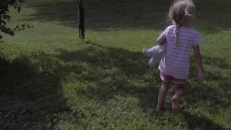 cute girl running into frame and running out of frame, copy space, grass field in summer, slow motion