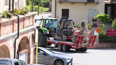 tractor towing machinery through a small italian town