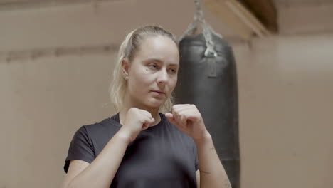 medium shot of confident female boxer getting ready for kick