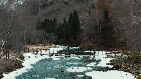 antena a lo largo de un río congelado y a través de un pequeño puente en noruega