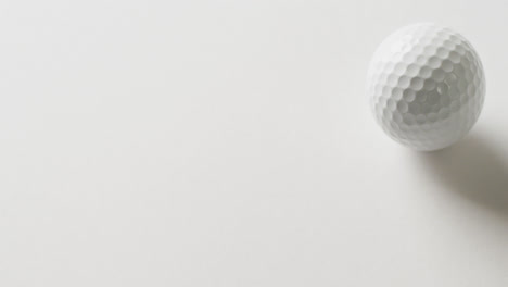 Close-up-of-golf-ball-on-white-background,-copy-space,-slow-motion