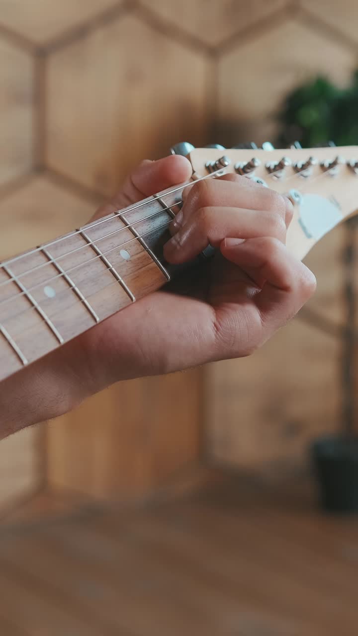 Young african american man composer with guitar in hands makes notes in notebook