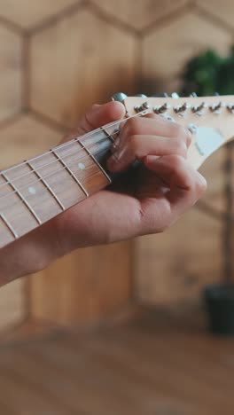 Young african american man composer with guitar in hands makes notes in notebook
