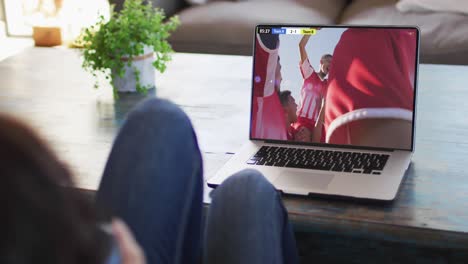 Video-Einer-Frau,-Die-Auf-Dem-Sofa-Sitzt-Und-Zu-Hause-Auf-Dem-Laptop-Fußball-Schaut