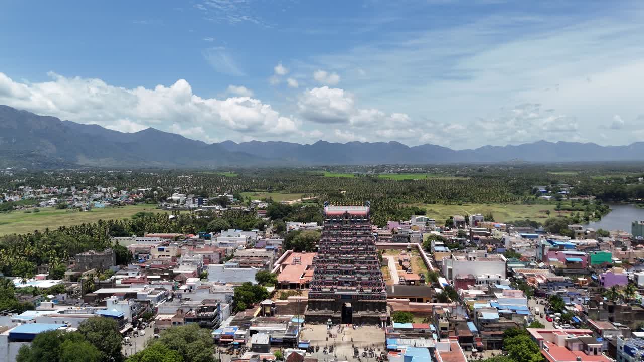 Aerial footage of Tenkasi’s iconic Kasi Viswanathar Temple rises above bustling streets, surrounded by vibrant fields and hills under a wide, blue sky