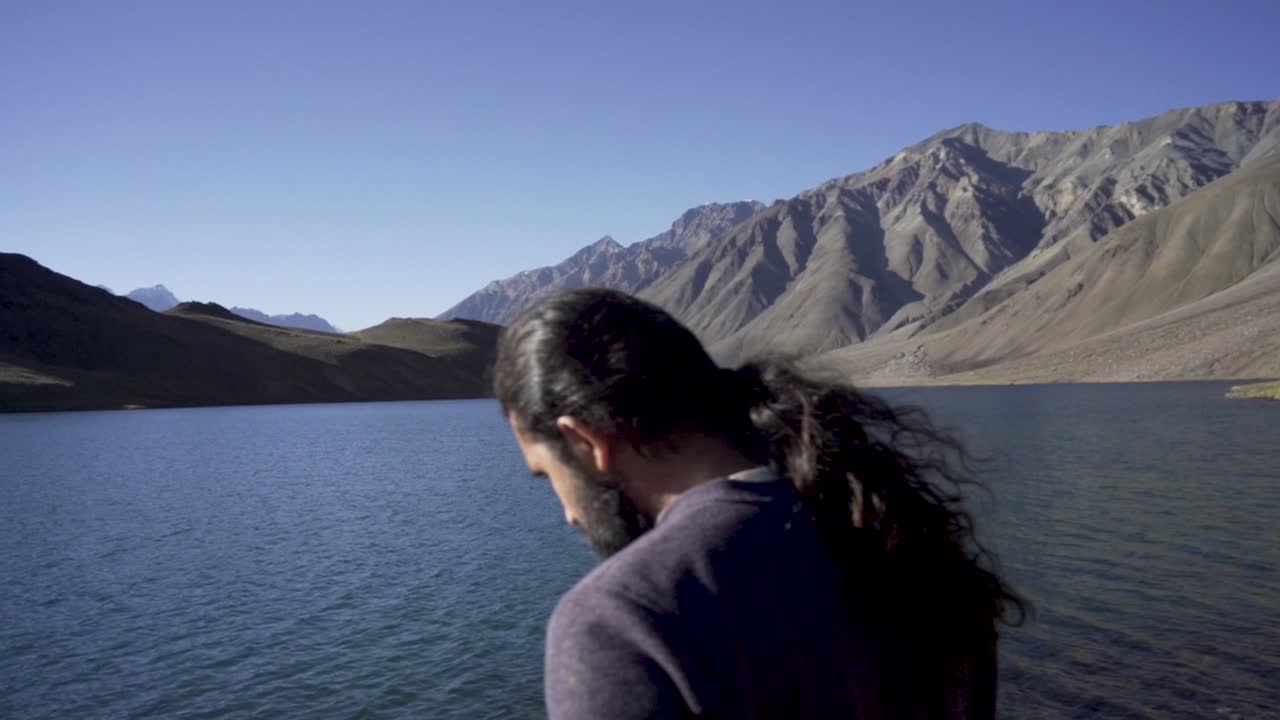 joven disfrutando de la naturaleza y sintiendo la belleza del lago chandratal, himachal pradesh