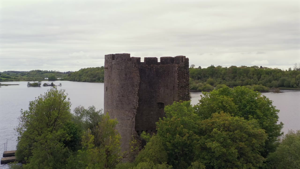 Pemandangan udara melingkar Kastil Cloughoughter pada senja yang tenang, menampilkan Danau Lough Oughter di latar belakang. Irlandia.