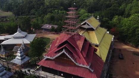 aerial shot of chinese houses situated in between the forest