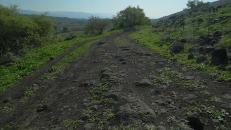 Una-Vista-De-ángulo-Bajo-Que-Muestra-Colinas-Yermas-Y-Terrenos-Rocosos-En-Las-Montañas-Bajo-Un-Cielo-Azul-Tranquilo