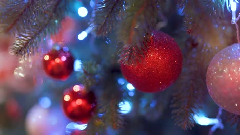 decorative toys on the christmas tree. red and white balls on green branches. light leaks and flare from the festive illumination