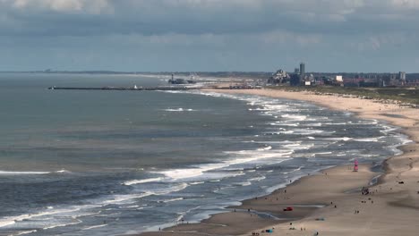 dutch seaside coastline with waves and cityscape