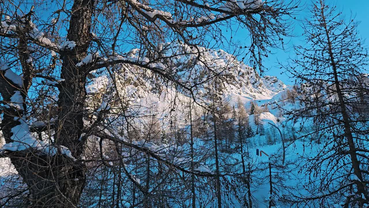 Utsikt over et snødekt fjell med nett under, fra et bevegelig skitrekk i Alpene