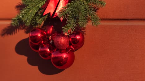 hermosas decoraciones navideñas rojas y verdes aisladas en la pared roja