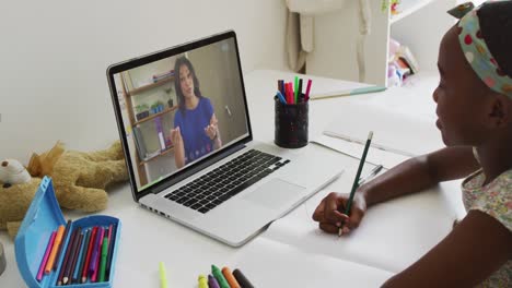 african american girl sitting at desk using laptop having online school lesson