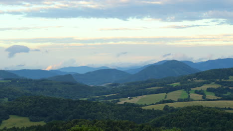 side slide evaporating low clouds over a mountainous landscape full of hills during a sunny day after a short rain when the water evaporates from the surrounding forests