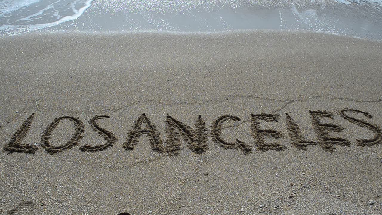 Indskrift i sandet. Optagelse på stranden.