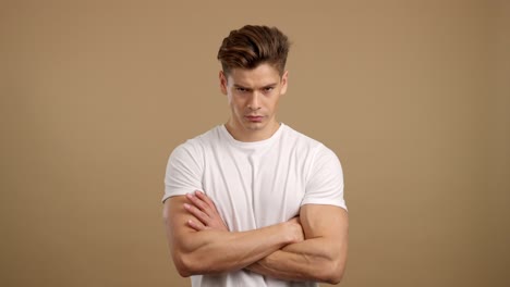 young man with crossed arms and frowning expression