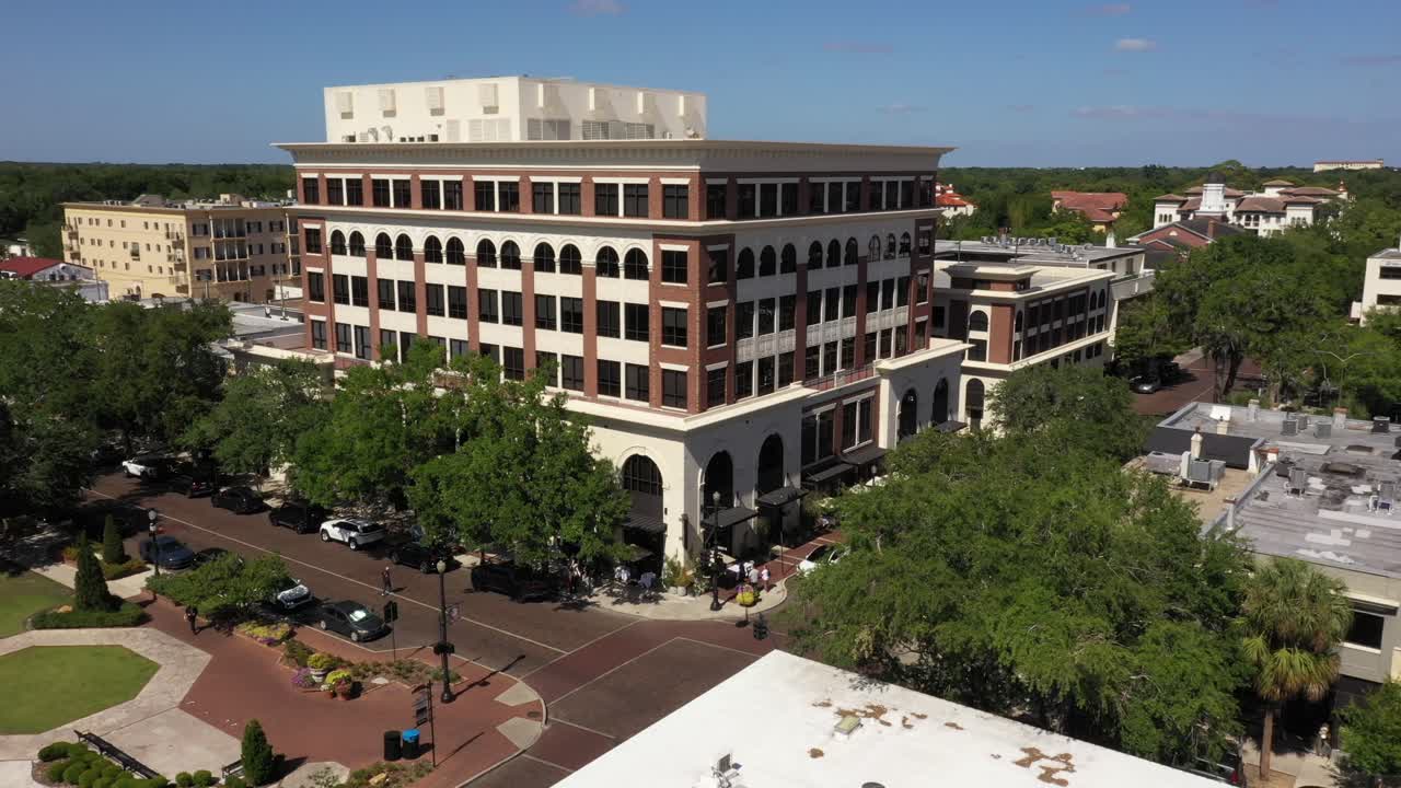 Drone orbit of a central plaza in Winter Park, with traffic and multi story buildings