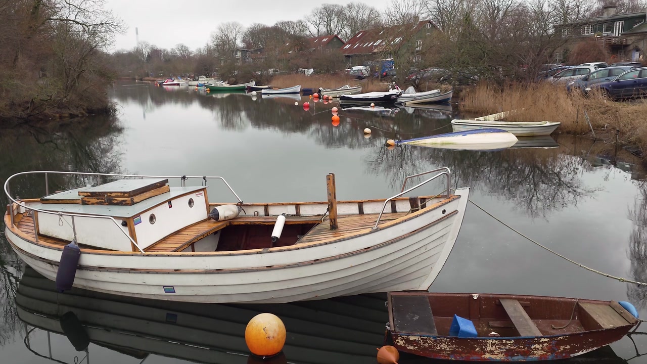 Small boats docked on the river in Freetown Christiania - Copenhagen, Denmark