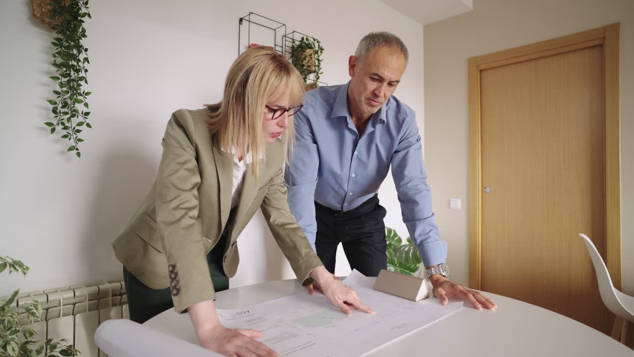 Business meeting discussing blueprints