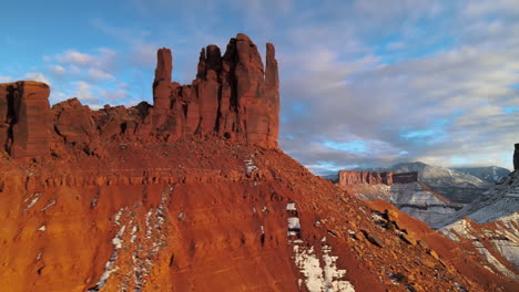 sunset aerial panning shot of sandstone towers near moab, utah, in wintertime