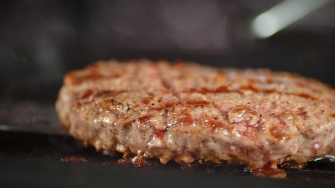 la hamburguesa de carne de res jugosa está frita en una sartén.