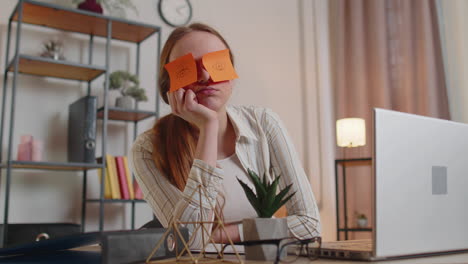 Una-Profesora-Cansada-Que-Usa-Una-Computadora-Portátil-Con-Graciosas-Pegatinas-En-Los-Ojos-Duerme-En-El-Lugar-De-Trabajo,-Tomando-Una-Siesta