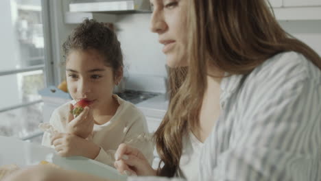 mother and little daughter bonding and using tablet on breakfast