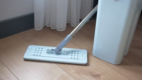 light blue mop and bucket on wooden floor