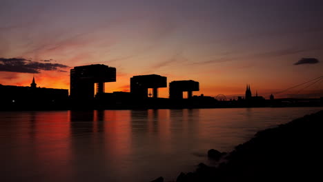 Farbenfroher-Tag-zu-Nacht-Zeitraffer-Von-Kölner-Kranhäusern-Und-Dem-Rhein-Im-Vordergrund