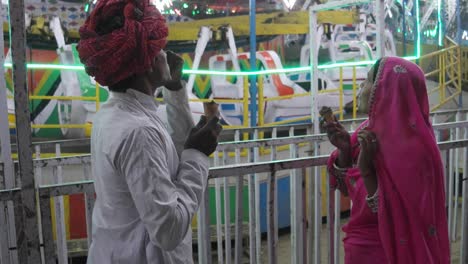 indian couple eating ice cream in traditional dresses at the pushkar mela, a carnival of rajasthan, india