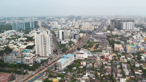 Toma-Aérea-De-Drones-De-La-Ciudad-De-Chennai-En-Una-Zona-Comercial-Con-Tráfico-De-Coches-Y-Edificios.