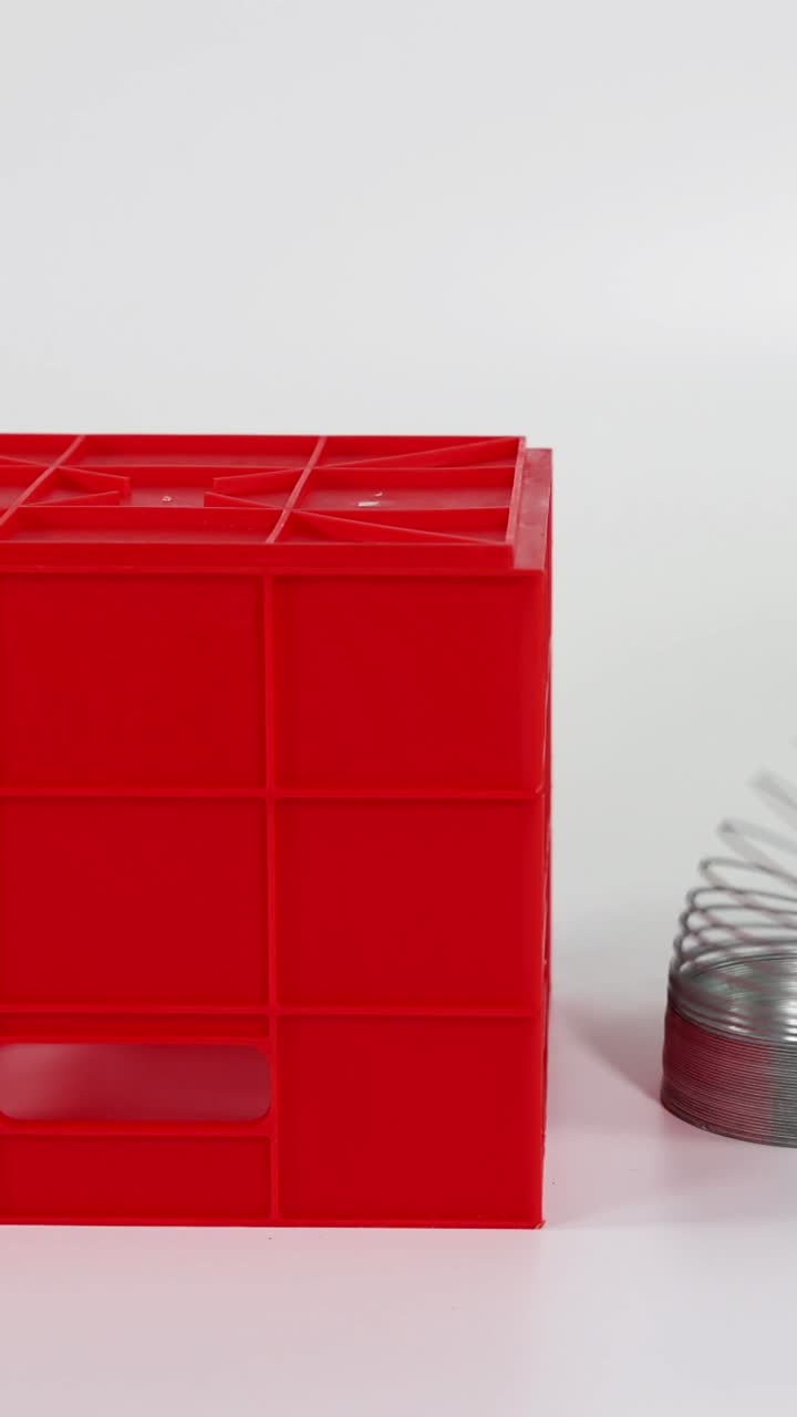 Tangan memainkan mainan slinky di atas tangga balok merah