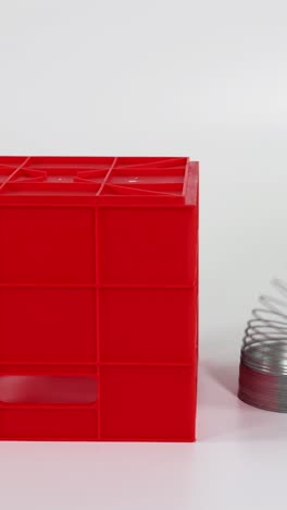 las manos manipulan un juguete elegante sobre las escaleras de bloques rojos.