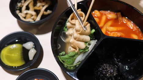 Woman-takes-Korean-Odeng-or-Fishcake-off-Wooden-Skewer