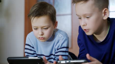 preschool boys playing on smartphone. peaceful pastime. technology and lifestyle concept