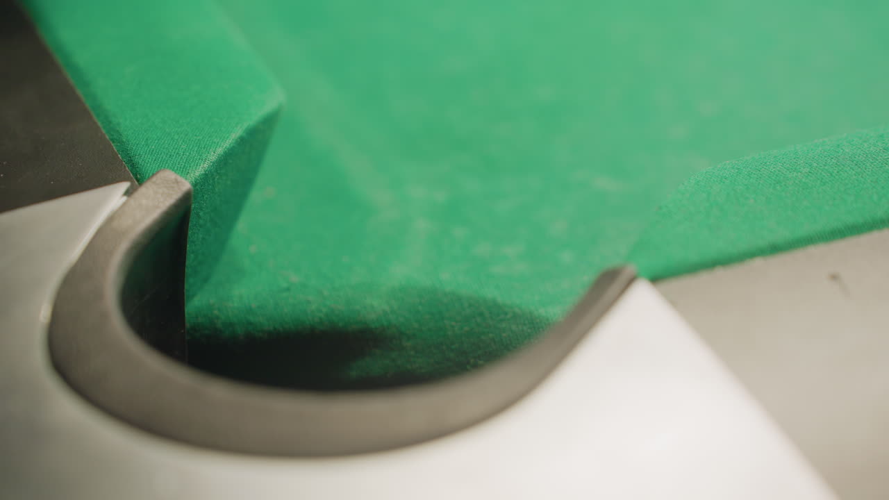 vista de cerca a la izquierda de la pelota de billar roja rodando rápidamente en el bolsillo de la mesa de billar en la superficie verde. el borrón de movimiento captura la velocidad, la precisión y el momento final del tiro, enfatizando la precisión, la competencia