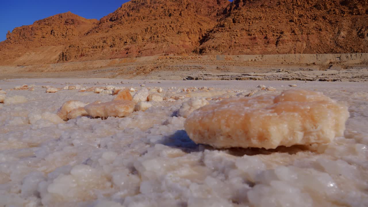 A close-up view of salt formations and rocks on the shore of the Dead Sea in Jordan.