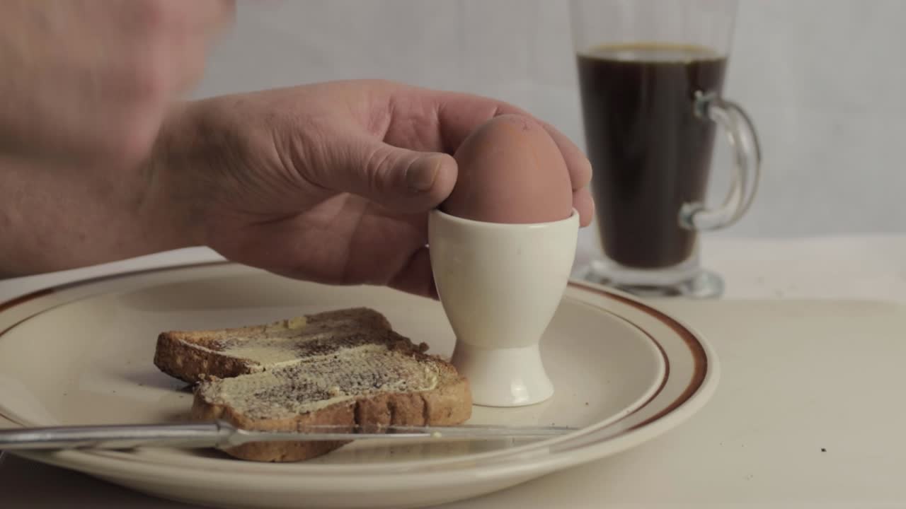 Hand smashing boiled egg with toast wide shot