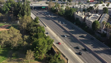 toma panorámica aérea de drones sobre filas de edificios residenciales junto a la autopista 101 en california, ee.uu. durante el día