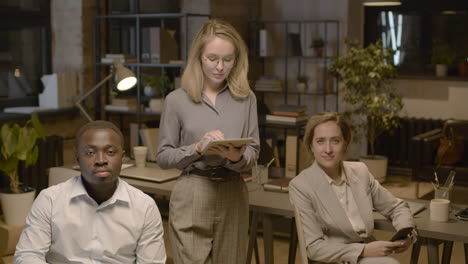 american man employee and female coworker sitting on a chair and looking at camera in the office 1