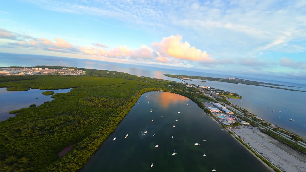 Flying over the green islands creating a bay in the vast waterscape. Numerous boats and yachts are on the anchor. Footage from FPV drone.