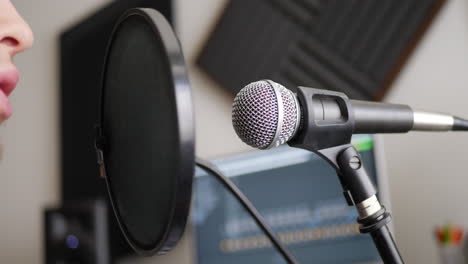 Primer-Plano-En-Un-Micrófono-Vocal-De-Estudio-Con-Un-Vocalista-Cantando-Durante-Una-Sesión-De-Grabación-De-Podcast-En-Un-Estudio-De-Música-De-Dormitorio