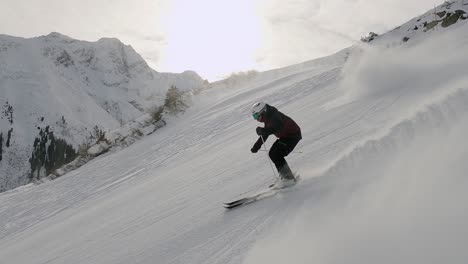 professional male skier skiing fast ski turns on perfect ski slope in tyrol