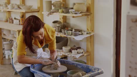 young female potter working in her studio