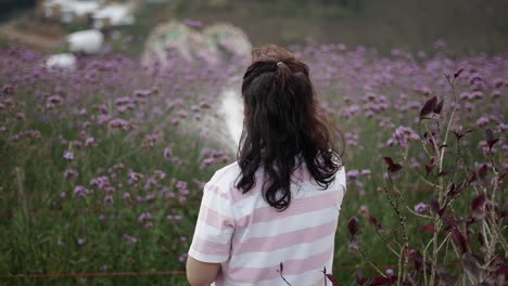 person from behind in a field of purple flowers