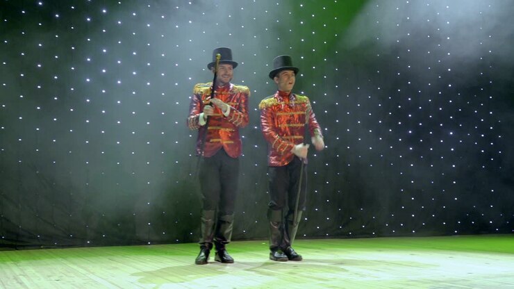 Uomini che ballano e cantano in duetto sul palco a teatro