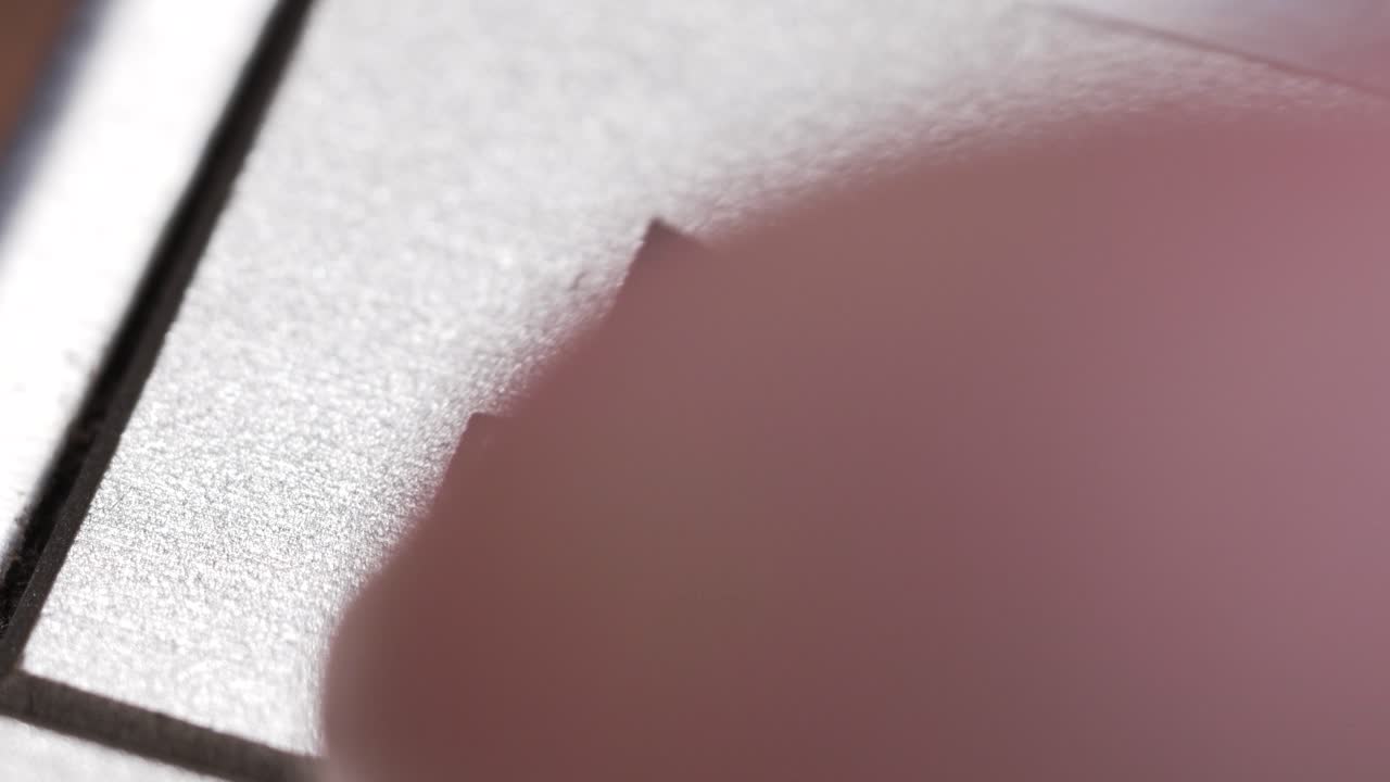 Makroaufnahme einer Fingers, der auf einen silbernen Play-Button mit schwarzem Dreieck-Icon drückt